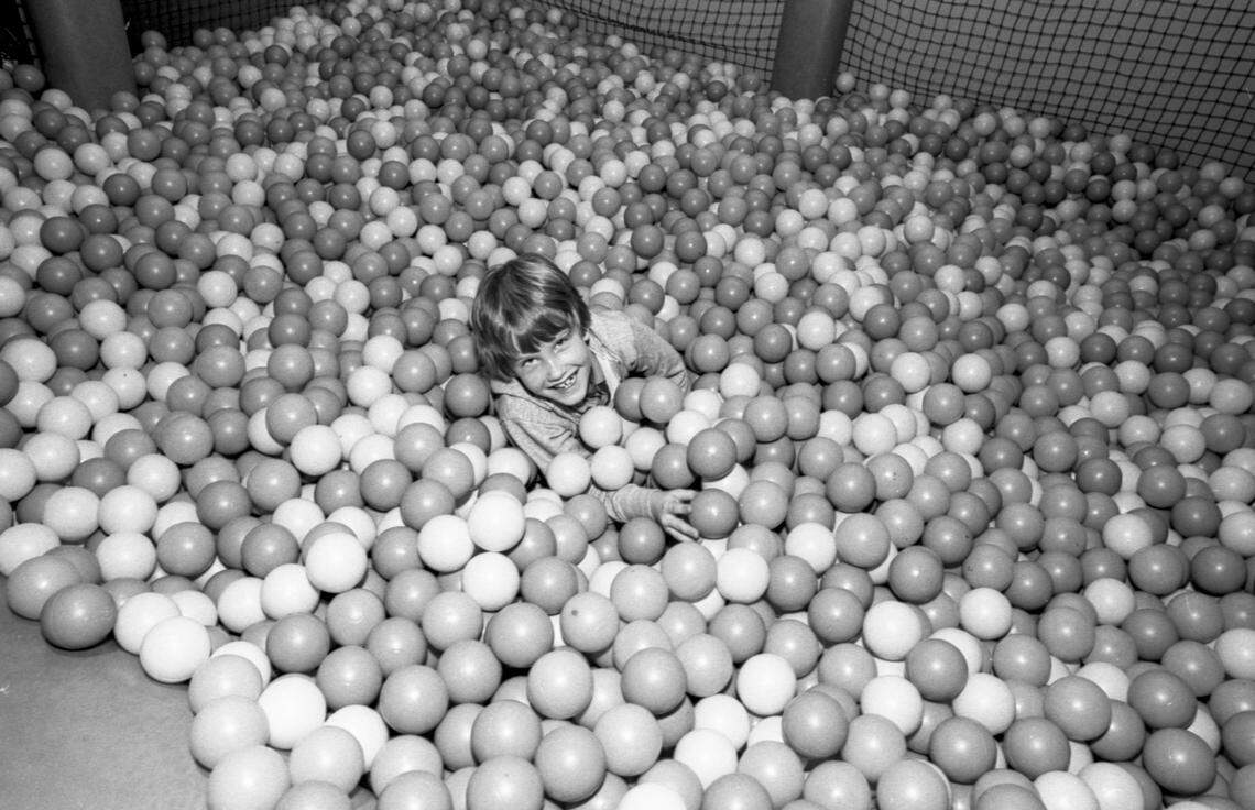 Steve Guynn, 7, wallows in the Beach Ball Bear Swim, a tank filled with soft rubber balls, at ShowBiz Pizza Place, Wednesday, Jan. 4, 1984 at Woodhill Circle Plaza in Lexington, Ky. Children would insert a token and then play in the ball pit. In 1991 the restaurant was rebranded Chuck E. Cheese and in 2025 it closed. Photo by Christy Porter, Herald-Leader file photo