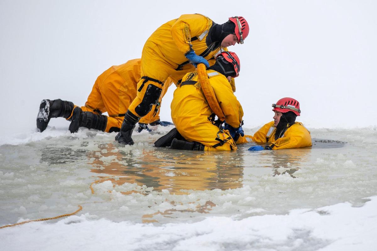 Members of the Lexington Fire Department participate in ice water rescue training at Jacobson Park in Lexington, Ky., on Friday, Feb. 19, 2021.