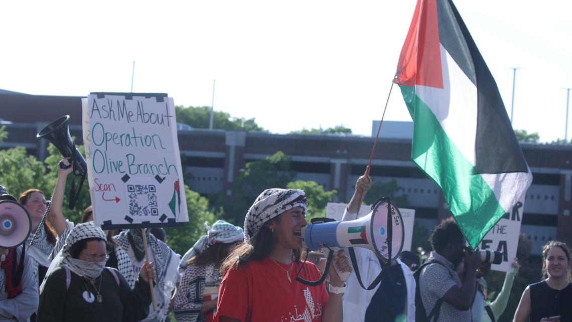 The Palestinian flag waves as the rally organizer leads the rally during the peaceful Free Palestine rally at the William T Young Library lawn on UK’s campus on May 1, 2024, in Lexington, Ky.