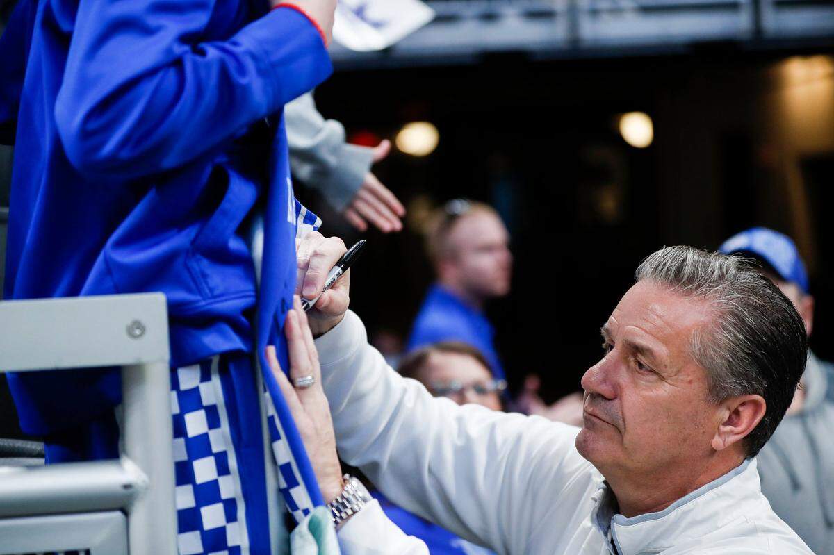 Kentucky Wildcats head coach John Calipari signs a jersey for a fan after an open practice before the first round of the NCAA Tournament at Gainbridge Fieldhouse in Indianapolis, In., Wednesday, March 16, 2021.