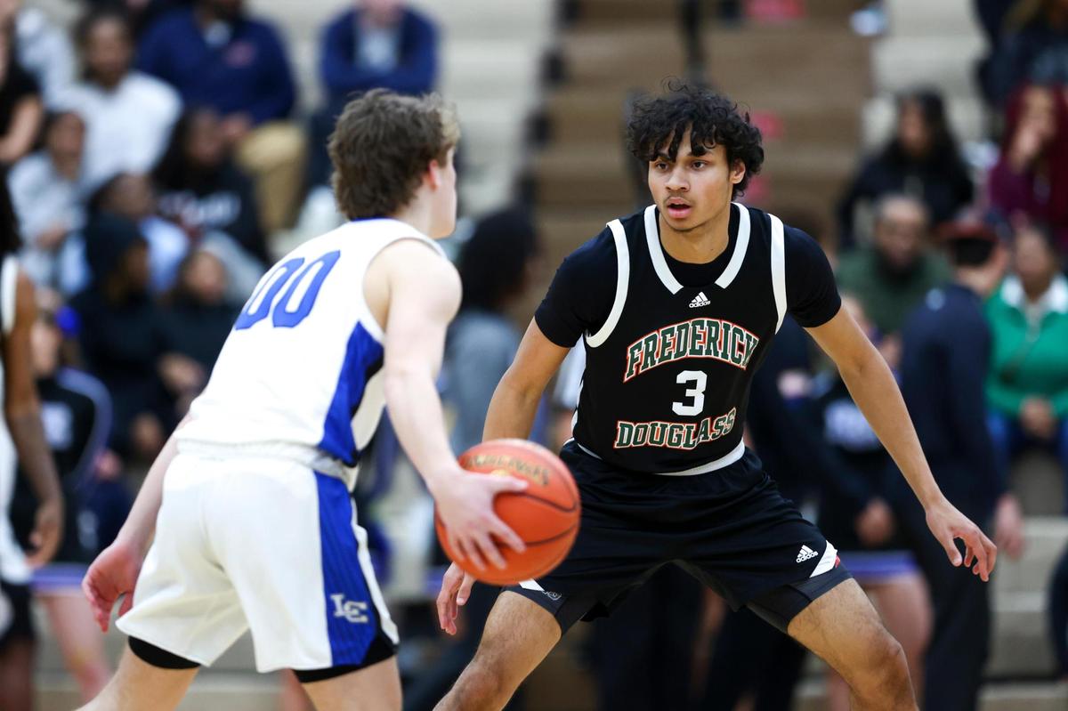 Frederick Douglass’ DeMarcus Surratt (3) guards Lexington Catholic’s Jack Gambrell (0) during the 11th Region Tournament semifinals at Paul Laurence Dunbar High School’s S.T. Roach Sports Center on Saturday.