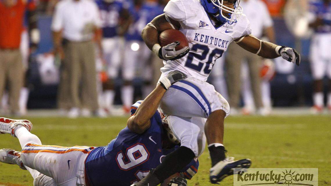 Kentucky s Derrick Locke was dragged down in the second quarter  by Florida s Justin Trattou,94,  holding him to 49 yds in the first half as Kentucky played Florida on Saturday September 25 , 2010 in Gainesville, Florida. Photo by Mark Cornelison | Staff.