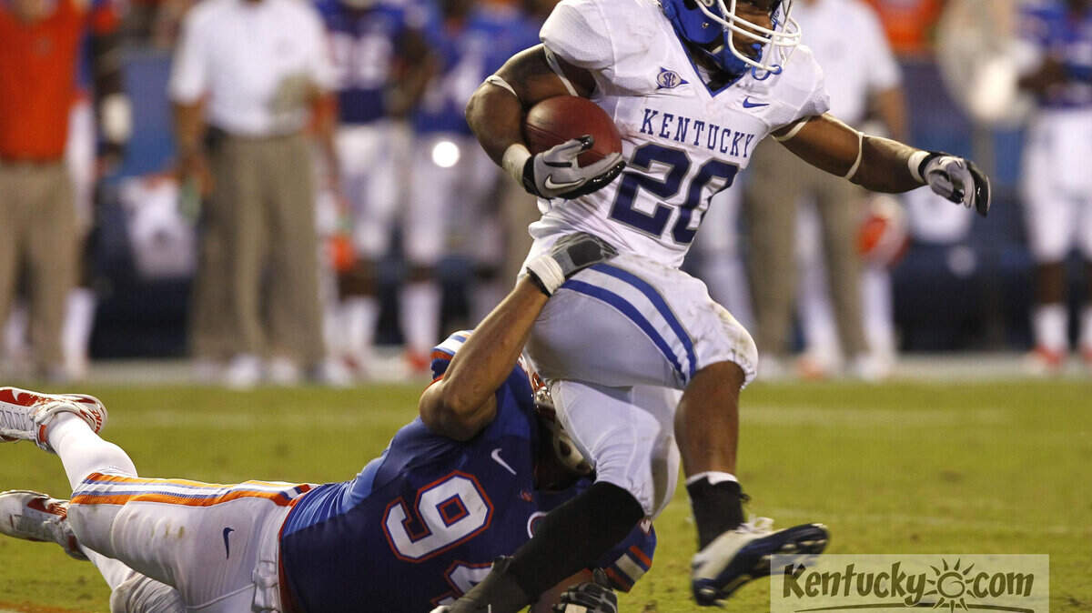 Kentucky s Derrick Locke was dragged down in the second quarter  by Florida s Justin Trattou,94,  holding him to 49 yds in the first half as Kentucky played Florida on Saturday September 25 , 2010 in Gainesville, Florida. Photo by Mark Cornelison | Staff.