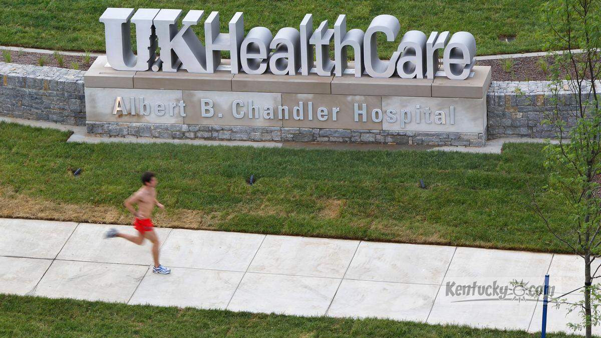 A runner ran by a sign for the University of Kentucky Albert B. Chandler Hospital at the intersection of South Limestone and Rose St. in Lexington, Ky.