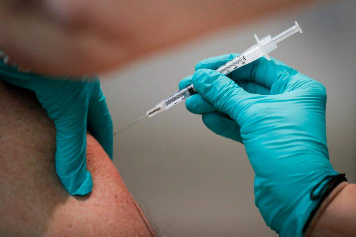 Physician assistant Christine Duttlinger, of Lexington, Ky., administers a dose of the COVID-19 vaccine to Navy veteran Joe Sheriff, of Booneville, Ky., at the Lexington VA on Veterans Drive in Lexington, Saturday, Jan. 16. 2021. The shot will be offered for all veterans 50 and over at this VA location through Monday.