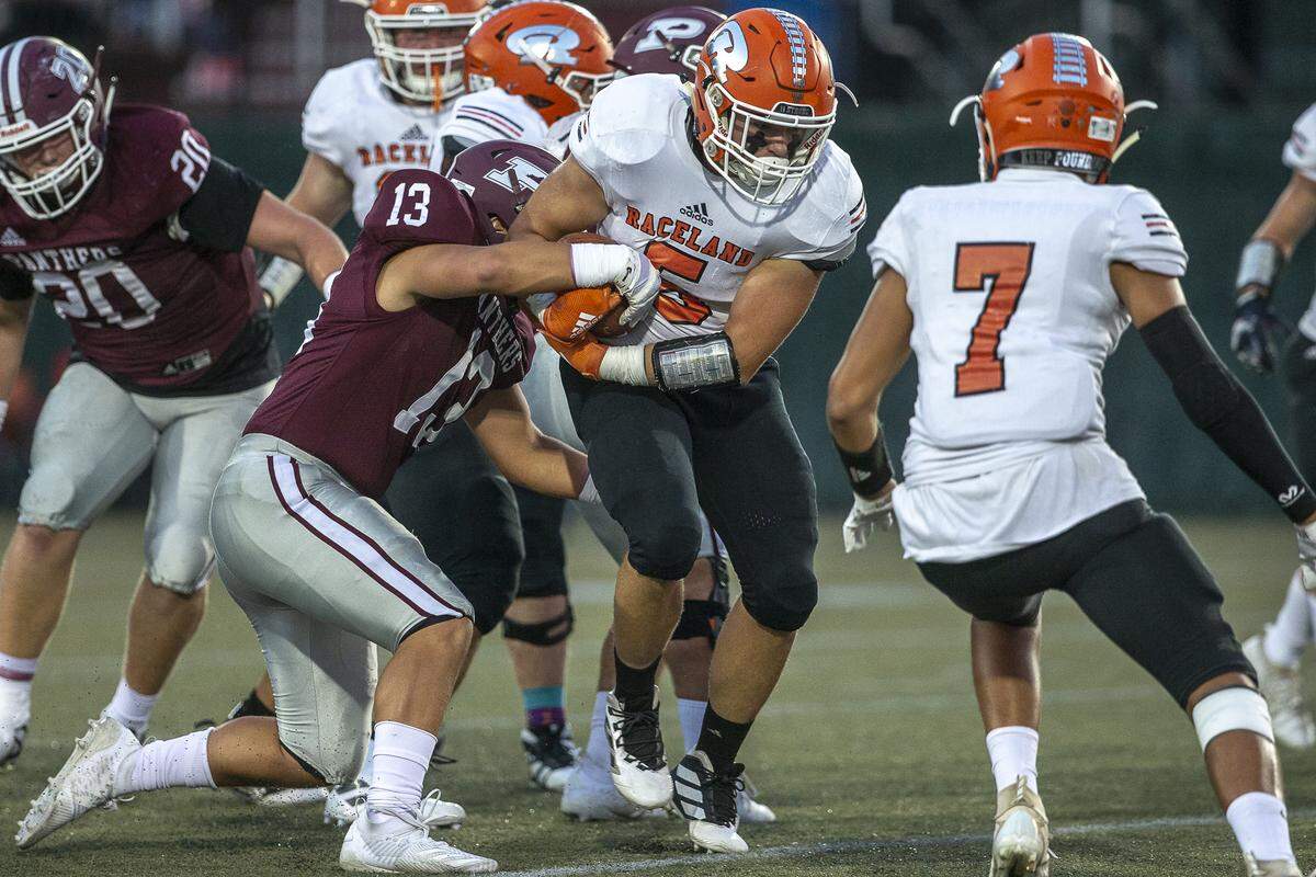 Pikeville’s Brody Birchfield (13) tries to strip the ball from Raceland’s Seth Mills (5).