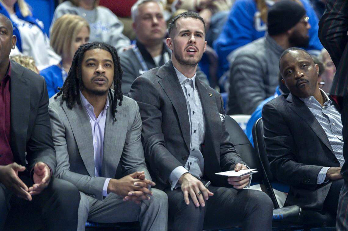 Arkansas assistant coaches Tyler Ulis and Brad Calipari watch the Razorbacks play against Kentucky at Rupp Arena on Saturday.