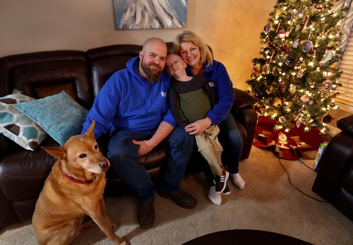 Zach Pickard with his parents, Brandon and Tina Pickard, and their dog Carmen, at their house in Lexington. Zach, who will turn 12 years old in January, was diagnosed with Progeria, an accelerated aging syndrome, in December 2007 at the age of 11 months.