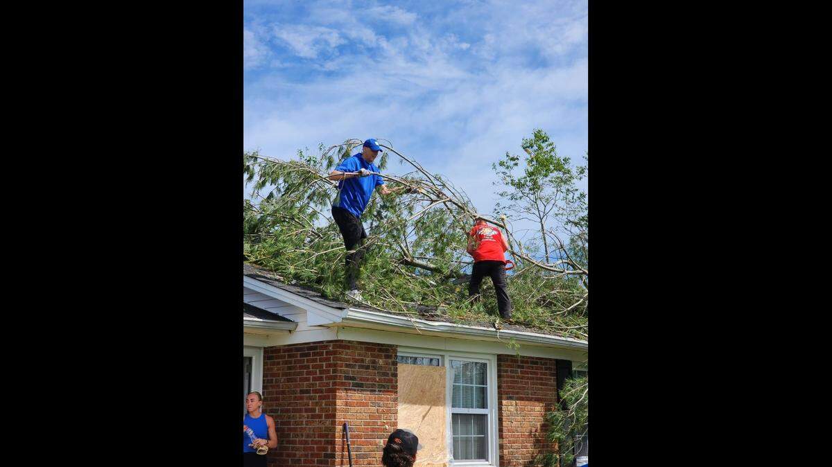 University of Kentucky men’s Basketball Coach Mark Pope is pictured cleaning up debris at a house in London, KY.