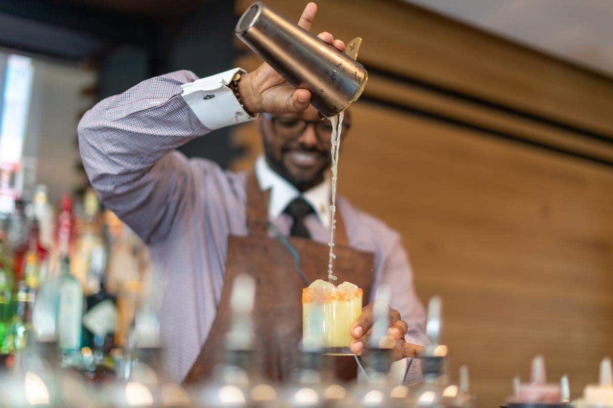 Kal Lemma, head bartender at the Watergate Hotel’s Kingbird Restaurant, puts the finishing touches on a specialty cocktail.