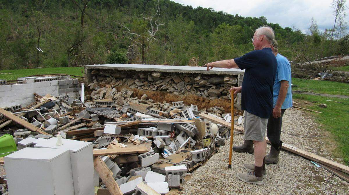 Davd Godby shows a neighbor where he was in the basement of a friend’s home when a tornado hit rural Pulaski County on May 16, 2025. Godby’s wife, Melodie, was in the house as well and died in the storm.