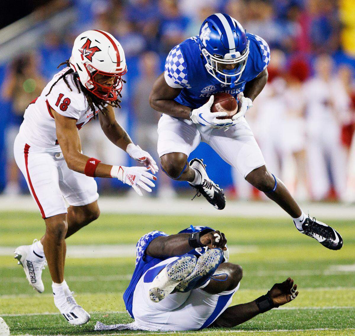 Kentucky defensive back Keidron Smith leaps over a teammate while intercepting a pass against Miami (Ohio) on Sept. 3.