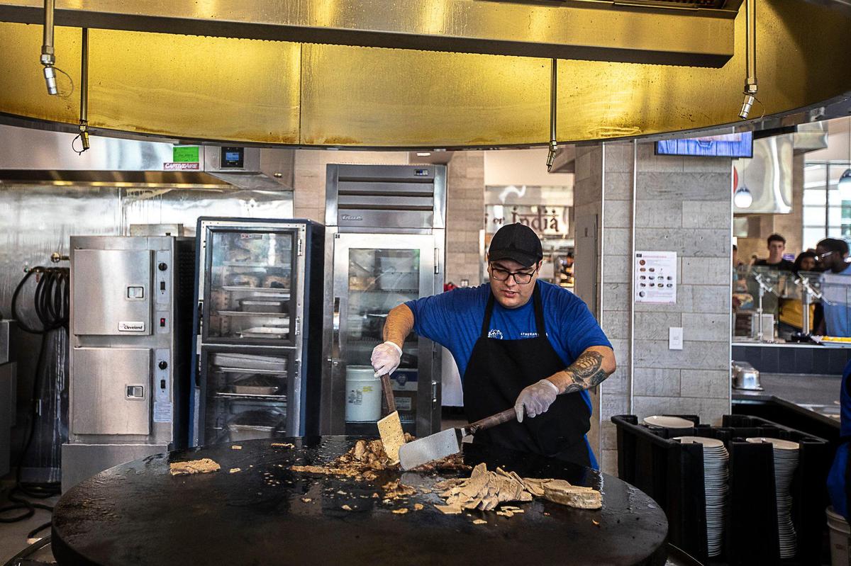 Hiram Perusquia prepares food Wednesday at the Athenian Grill’s location at The 90 on UK’s campus.