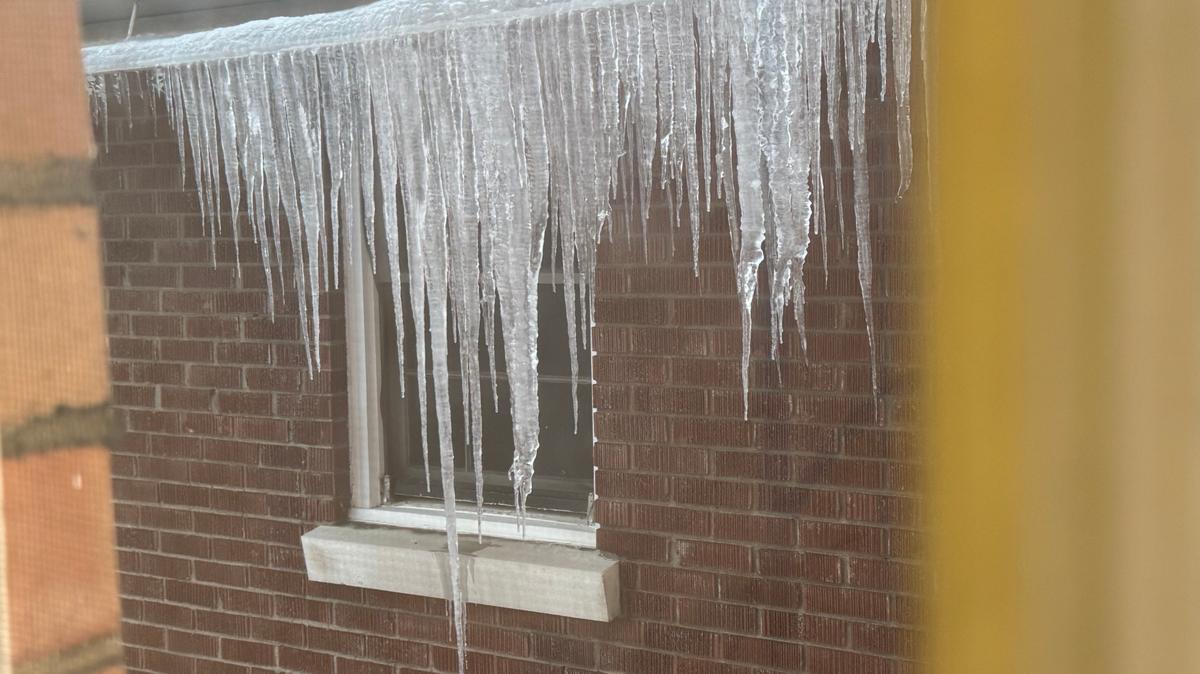 Massive icicles several feet long form on a Lexington home. Here, the icicles can be seen hanging from a frozen-over gutter as they extend down past a window on the side of a home.