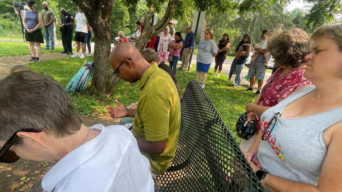 Members of the Pine Meadows community pray at the Lexington, Ky. park where a shooting took place on July 5, killing 16-year-old Christopher Valdez.