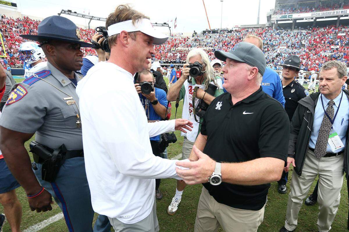 Sep 28, 2024; Oxford, Mississippi, USA; Mississippi Rebels head coach Lane Kiffin (left) and Kentucky Wildcats head coach Mark Stoops (right) shake hands after the game at Vaught-Hemingway Stadium. Mandatory Credit: Petre Thomas-Imagn Images