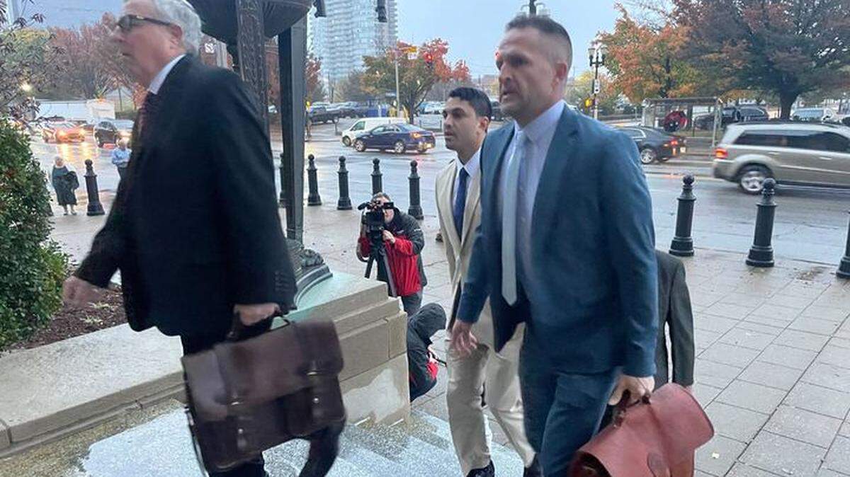 Brett Hankison (right), arrives in court alongside his attorneys for the beginning of a federal trial to determine if he violated the civil rights of  Breonna Taylor, her boyfriend and neighbors. 