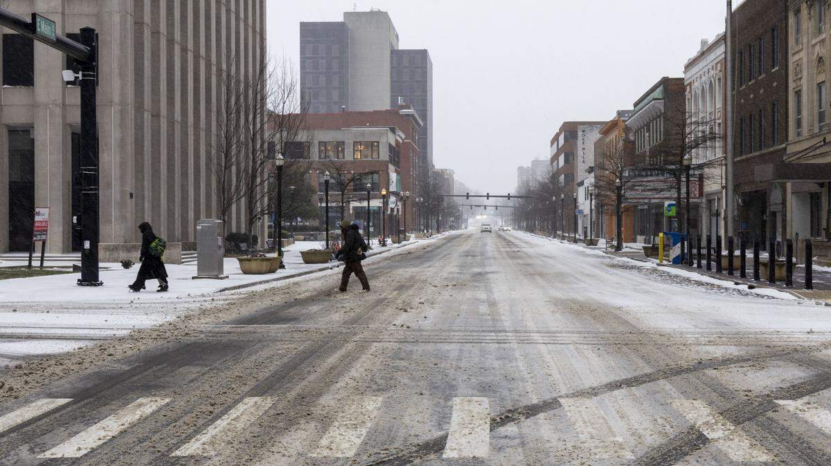Pedestrians cross Main Street in downtown Lexington Jan. 24, 2026, as Winter Storm Fern starts to bring heavy snowfall and sleet across Lexington and Central Kentucky.