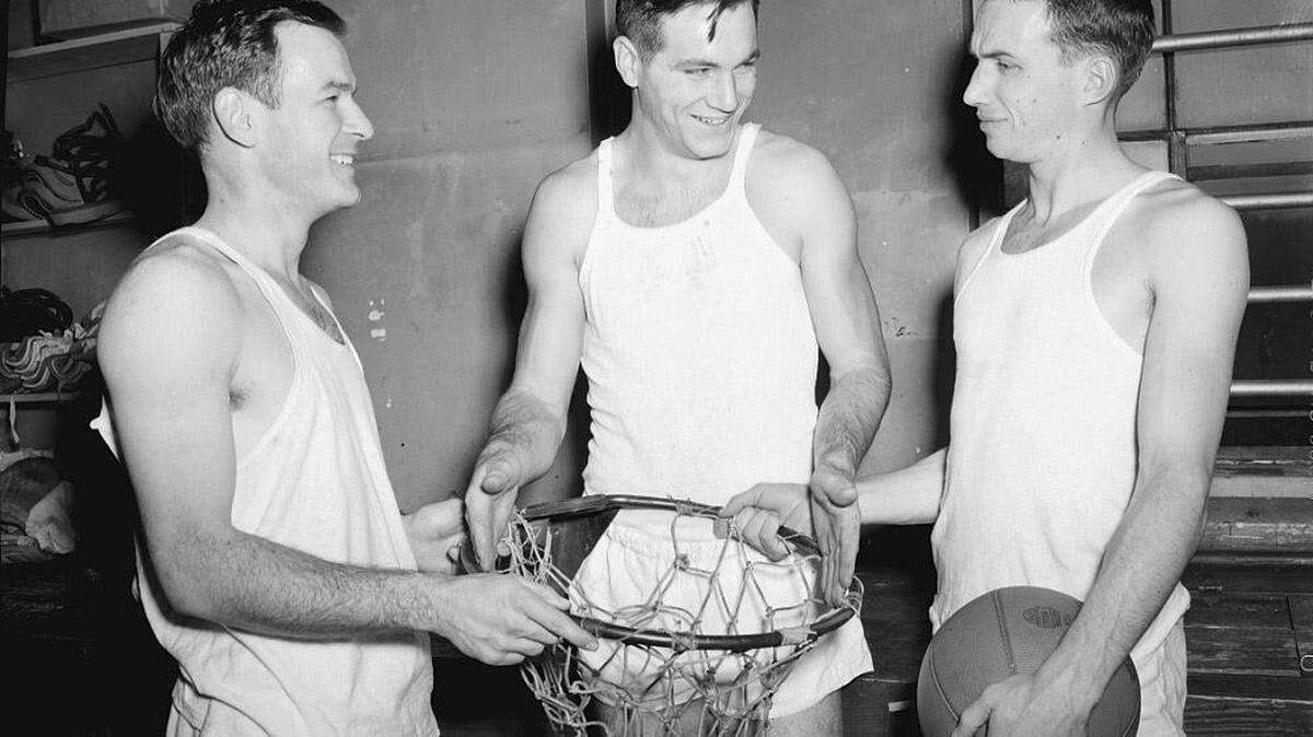 Kenny Rollins, right, UK captain, and Jack Parkinson, left, listened as Dutch Campbell explained that the hoops in professional basketball are no larger than those in the college game.