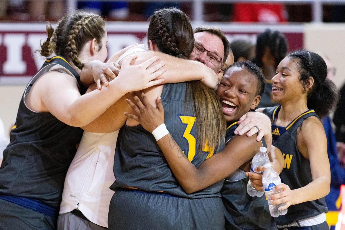 Franklin County Coach Joey Thacker hugs his daughter Gracie and the rest of her teammates after the Flyers defeated Lafayette on Saturday to win the 11th Region for the sixth time in eight years.