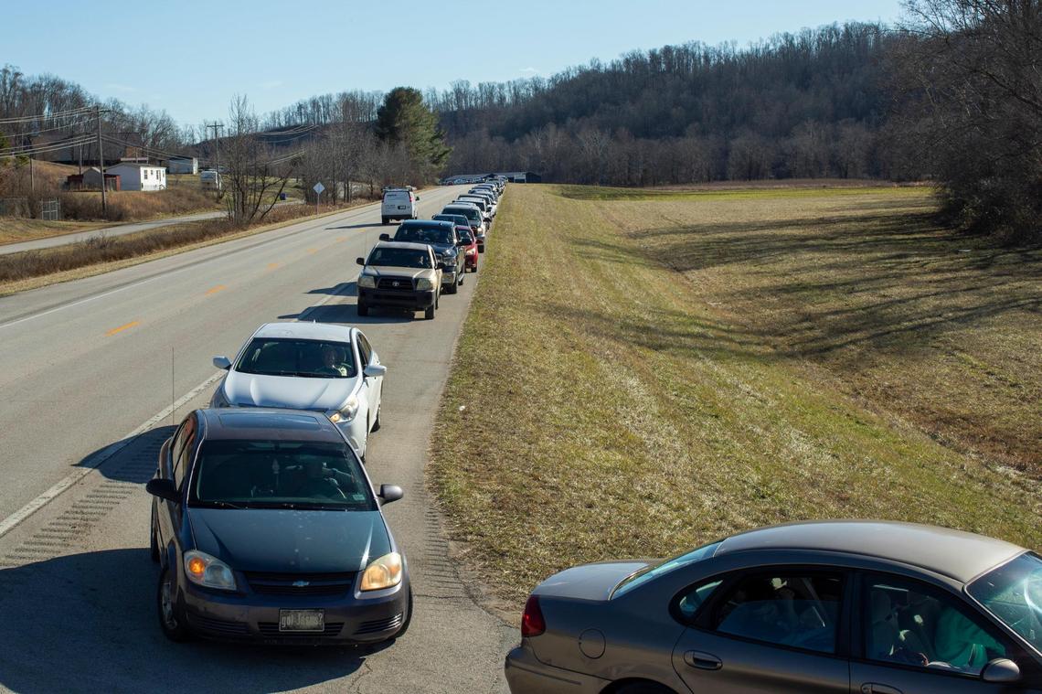 People line up to receive hot meals, food supplies and water from volunteers with Mercy Chefs and the Hazel Green Food project outside at the Hazel Green Food Project in Wolfe County, Ky., Thursday, January 19, 2023.