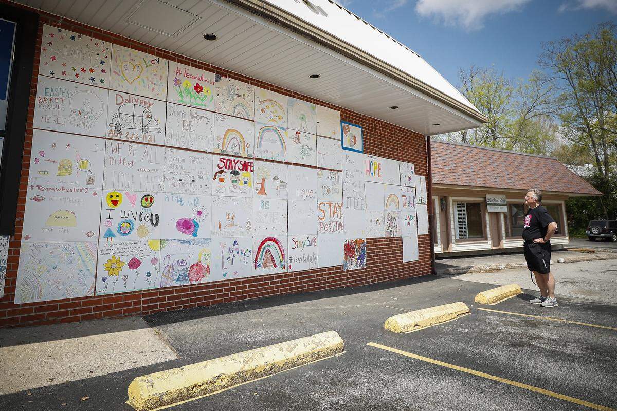 Ralph Hulett, of Erlanger, looks at hand drawn inspirational posters on display Wednesday at Wheeler Pharmacy on Romany Road.