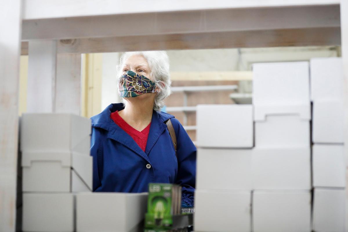 Mary Hughes looks over items such as green lightbulbs and hand sanitizer while shopping Thursday at Lexington’s Chevy Chase Hardware. During the coronavirus global pandemic they are expanding the store while selling face masks, cleaning supplies, hand sanitizer.