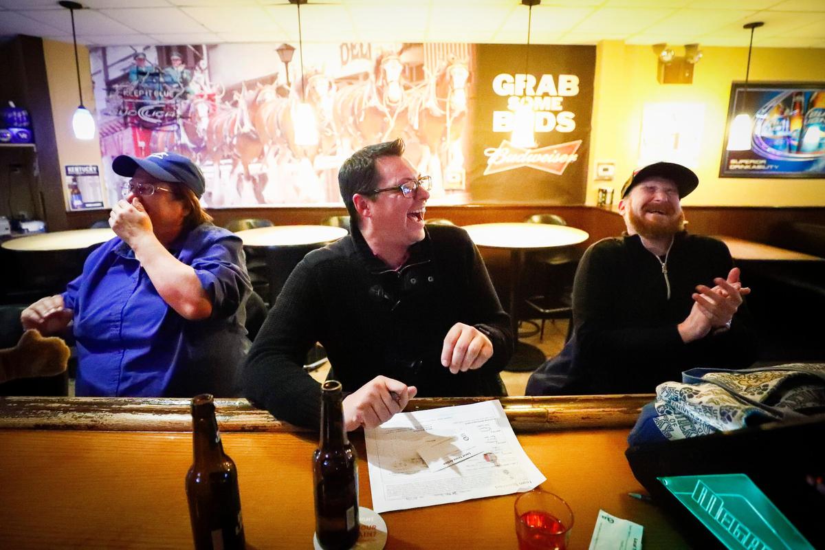 From left, Ellen Mills, Eric Dunbar, and Christopher Bartlett, erupt with laughter Dec. 11 while trying to answer trivia questions at Spud’s Sports Pub in Lexington.