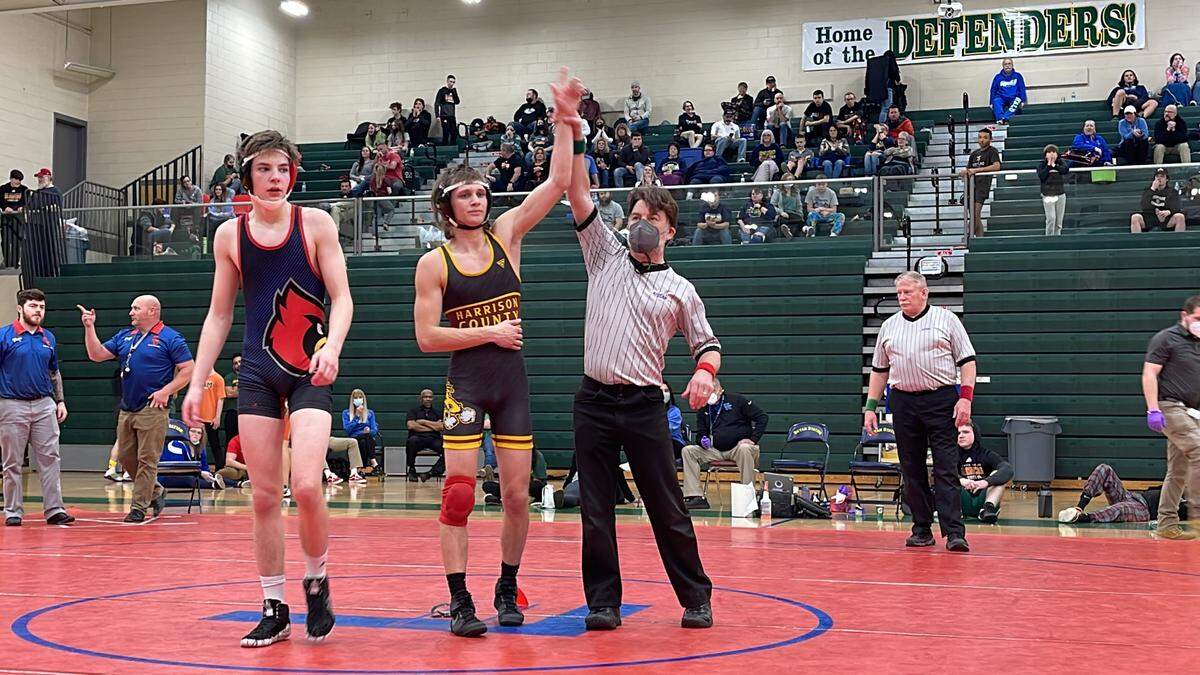 Harrison County’s Leydon Nelson favored his right arm as his left one got raised in victory in his championship match against Scott County’s Jonah Baysinger. Nelson injured his shoulder in the second period but held on to win the 120-pound weight class.