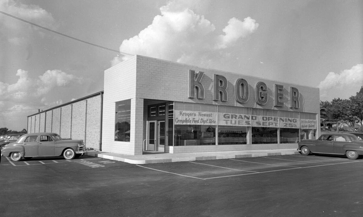 A new Kroger grocery store, located on Winchester Pike near Loudon Avenue, September 1951. The store, regarded as the latest in Kroger’s design of stores, had a 100-car parking lot with lights, self-service coffee grinders and air conditioning. There were four aisles, each of the 5.5-feet tall shelves lined with canned and bottled goods. The meat department had a self-service station and there were five electric conveyor-equipped checkout lines. The exit door of the store was opened automatically by a “magic carpet” opener, the automated door freeing filled arms.