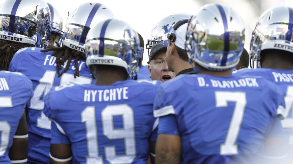 Kentucky head coach Mark Stoops gathered his team in a huddle during a time out in the second quarter of the Mississippi State at Kentucky at Commonwealth Stadium in Lexington, Ky., on Oct. 25, 2014. Photo by Pablo Alcala | Staff
