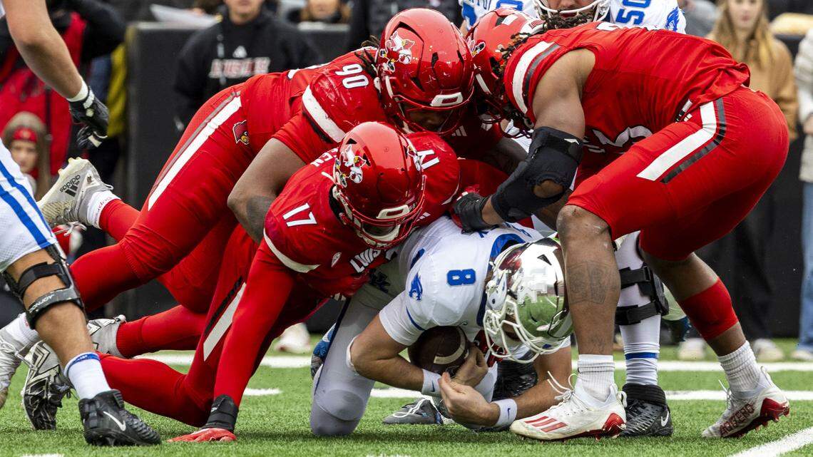 Kentucky quarterback Cutter Boley (8) is brought down by Louisville’s AJ Green (17), Rene Konga (90) and defensive lineman Wesley Bailey (23) during Saturday’s game.