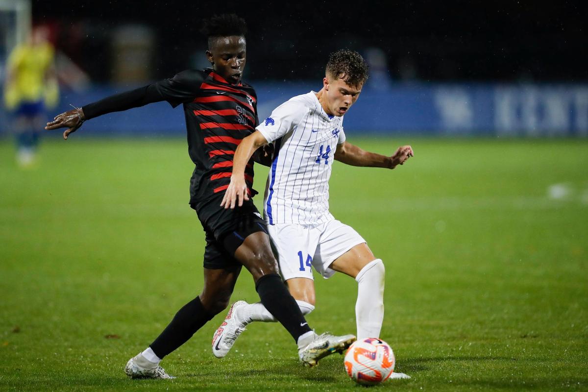 Kentucky’s Max Miller (14) dribbles the ball against Dayton midfielder Joseph Melto Quiah during Wednesday’s match at the Bell Soccer Complex.