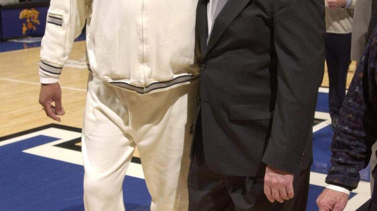 Melvin Turpin walked off the Rupp Arena court with former coach Joe B. Hall after 100 former lettermen were honored during halftime of a game against Mississippi State on Feb. 23, 2003.