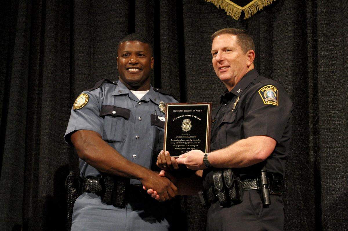 Lexington police officer Donnell Gordon, left, a former running back at Kentucky and Louisville, received the 2013 Field Training Officer of the Year Award from then-chief of police Ronnie Bastin.
