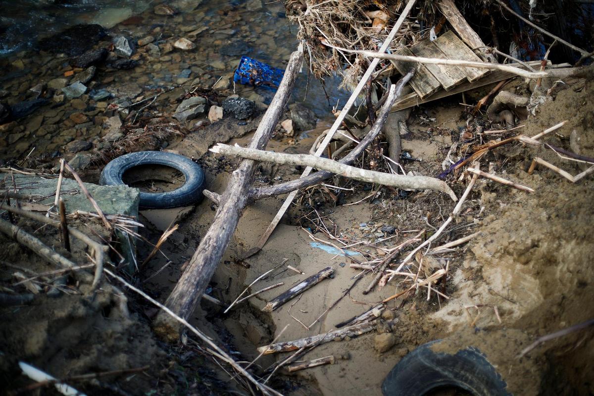 Debris sits piled up in Big Creek following a flood which damaged property along Smith Bottom Loop in Sidney, Ky., Thursday, Jan. 13, 2022.