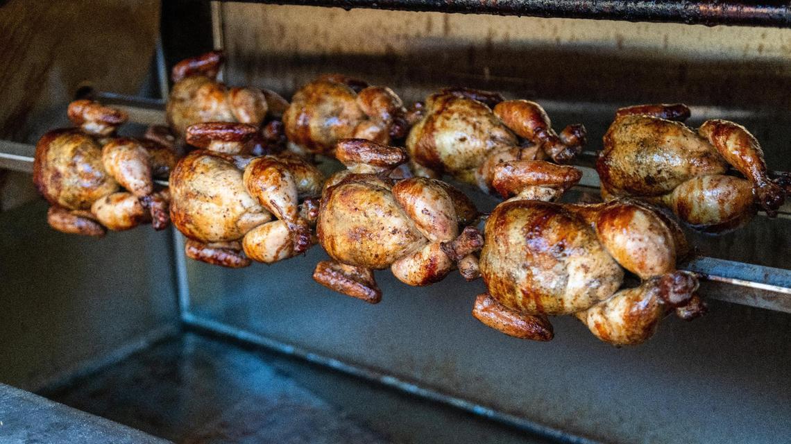Whole chickens slow cooking in an oven at Chic Charc Peruvian chicken style restaurant on Anniston Drive.