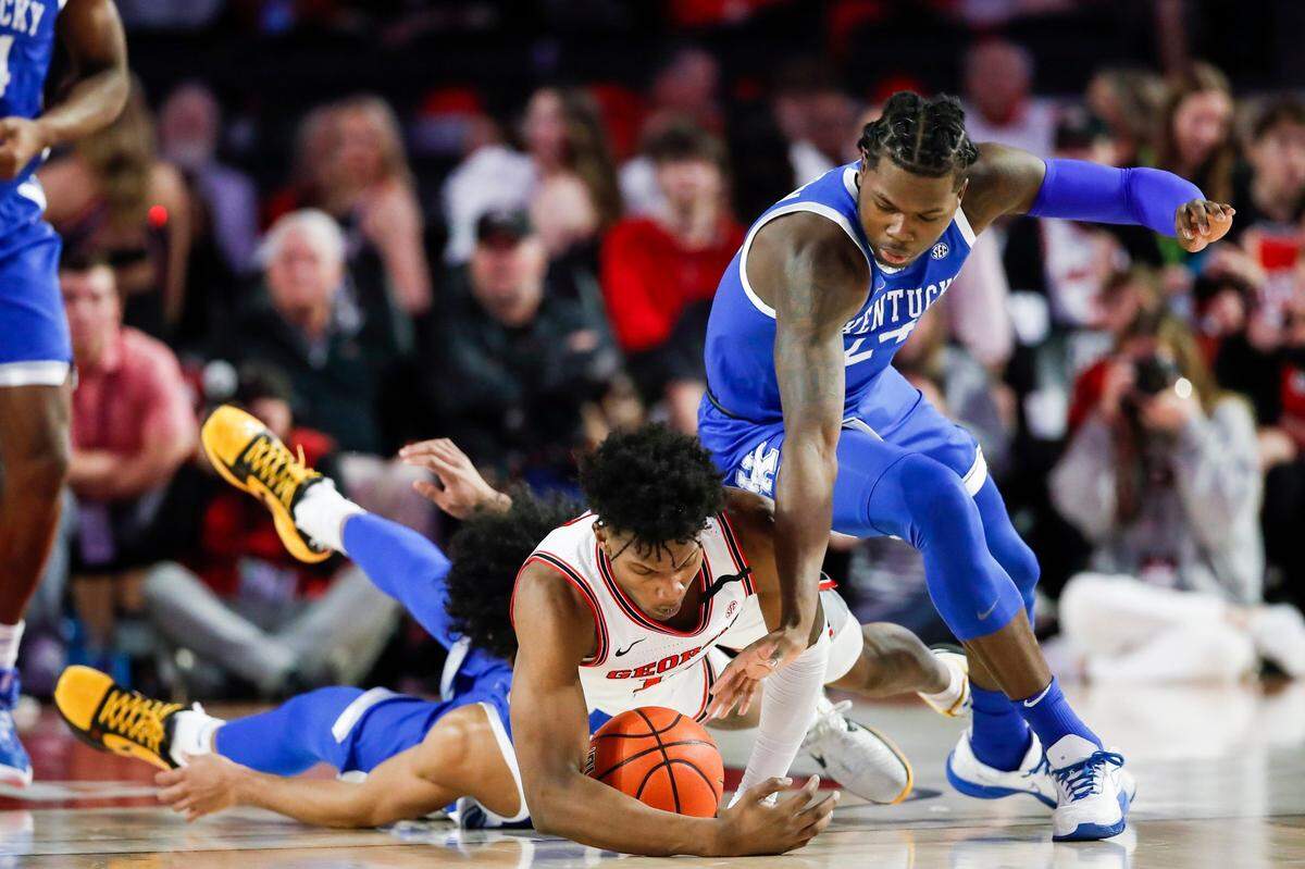 Kentucky’s Chris Livingston (24) dives for a loose ball against Georgia’s Matthew-Alexander Moncrieffe (12) during Saturday’s game at Stegeman Coliseum in Athens, Ga.