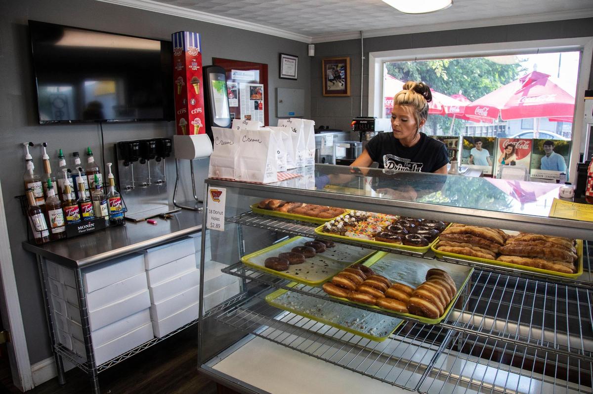 Assistant manager Laken Burchett prepares an order of doughnuts July 10 at the Drive-In restaurant in Olive Hill. Owner Todd Antrobus wanted to open a food trailer but he ended up buying a restaurant that had all the equipment to make doughnuts.