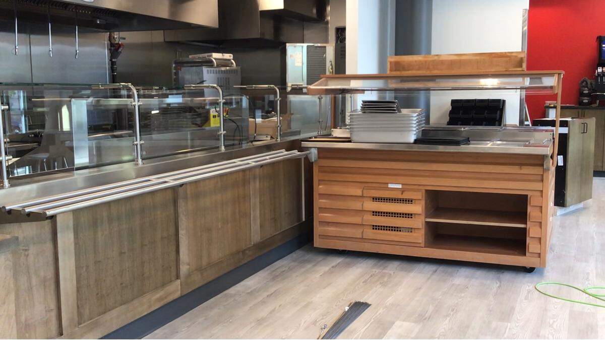 The new Sawyer’s Downtown Bar & Grill will include a smaller version of its popular burger, chili and salad bar, right, where customers can add their own toppings as they like after getting fresh grilled burgers.