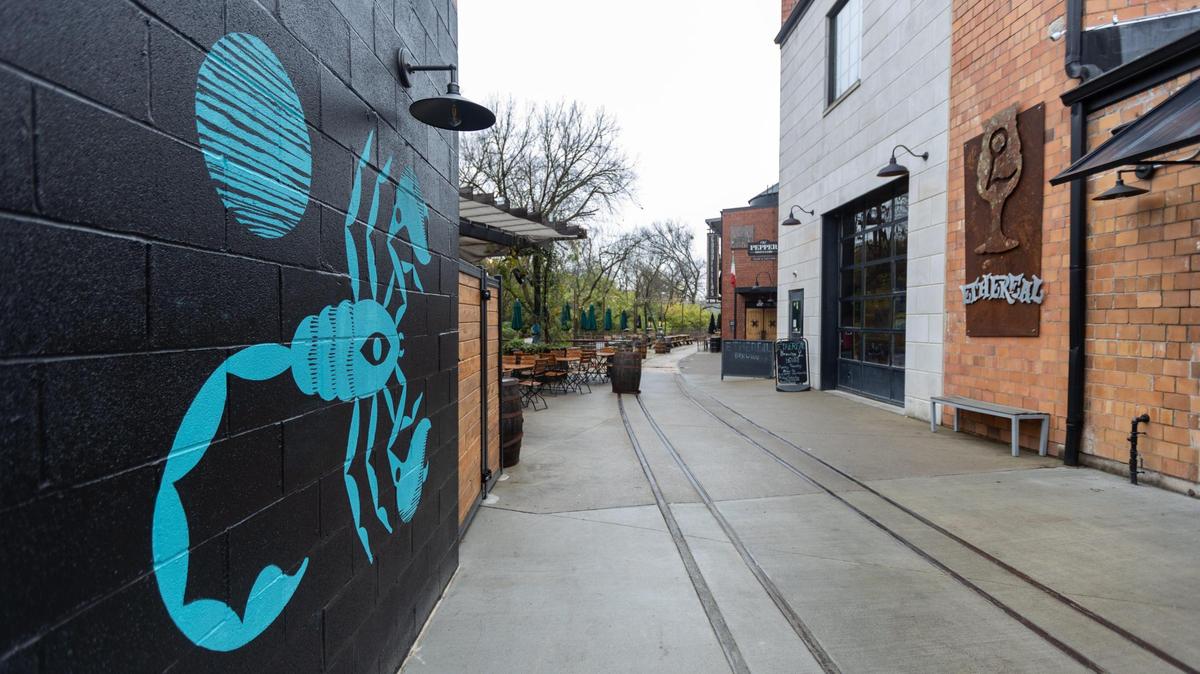 The scorpion logo of the Desperados restaurant painted on the side of the building faces toward Goodfellas Pizzeria and Ethereal Brewing.