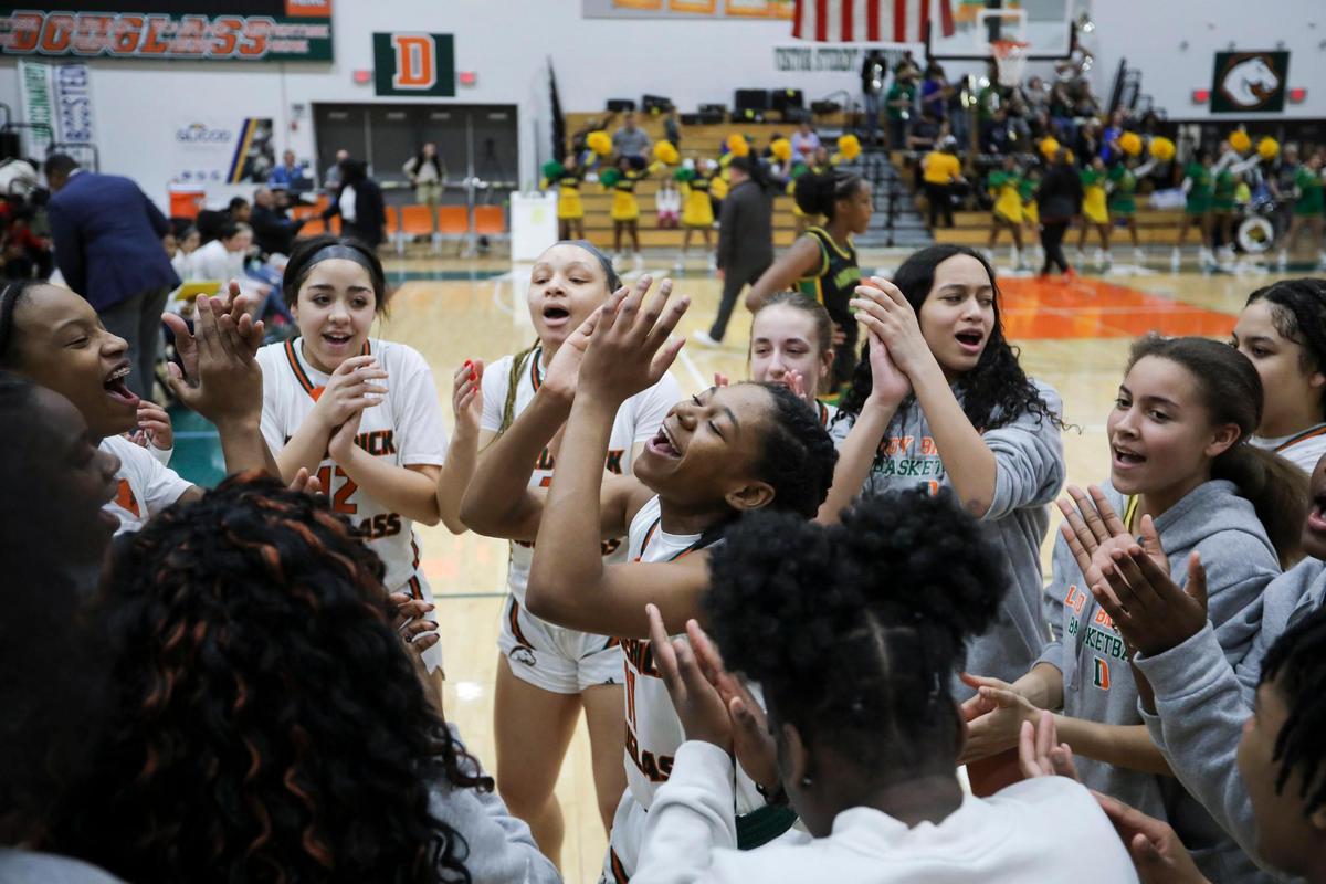 Frederick Douglass’ Mikalee Bennett, center, leads her team in a cheer before facing Bryan Station during the 42nd District championship game at Frederick Douglass on Friday. The Broncos will host Great Crossing on Monday in the 11th Region tournament.