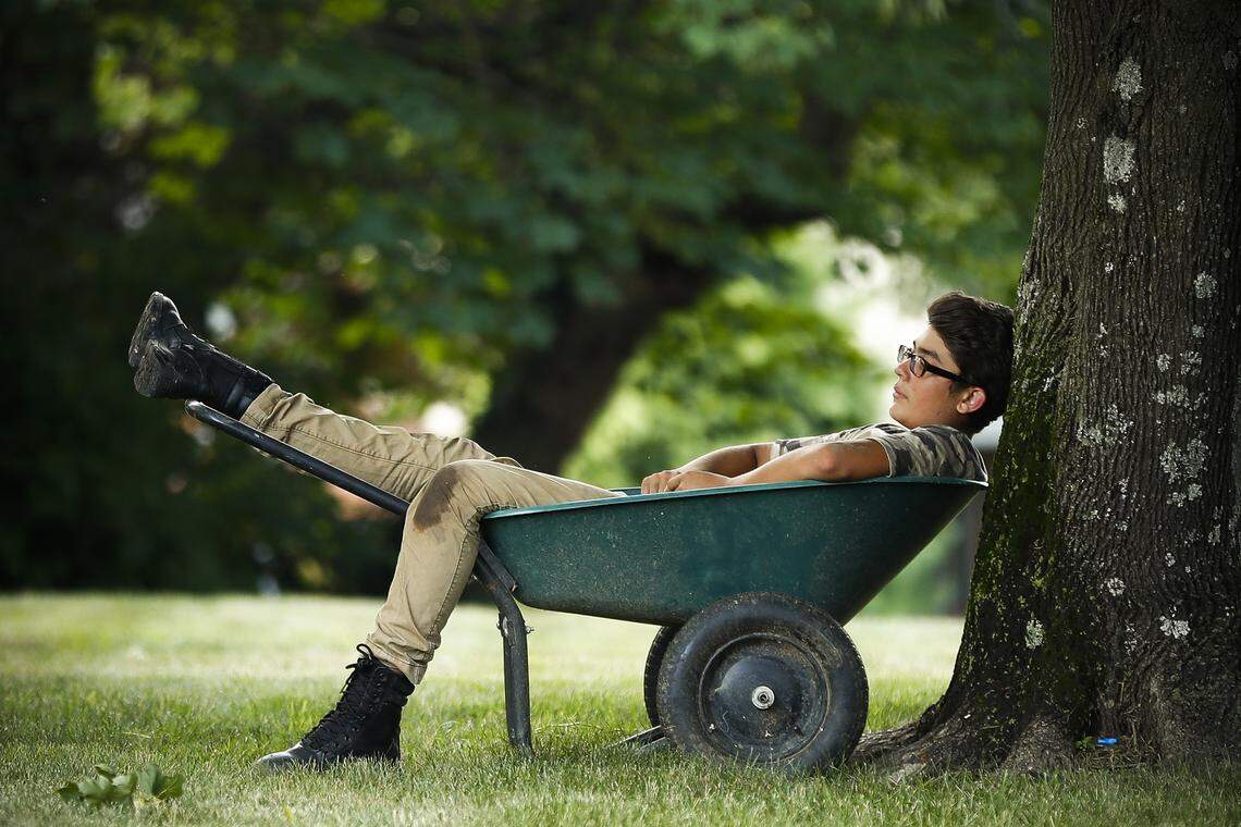 Brian Garfias, 14, of Lexington, Ky., takes a break from yard work at a neighbor’s home on Pimlico Parkway in Lexington, Tuesday, July 9, 2019.
