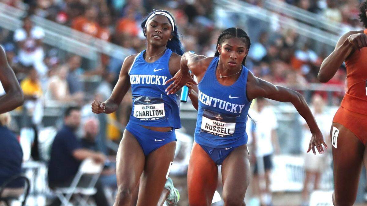 Kentucky’s Masai Russell takes the baton from teammate Anthaya Charlton during the 4x100 relay at the NCAA Outdoor Championships on Saturday. The Wildcats finished second.