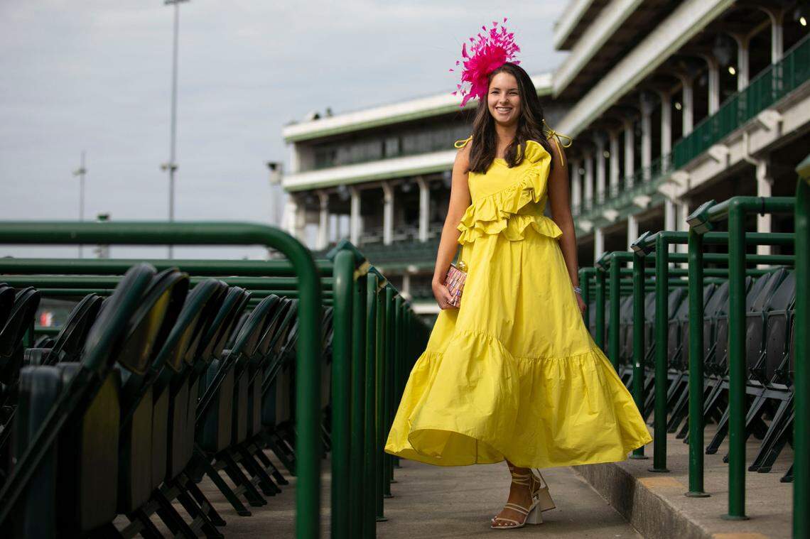 Elizabeth Montgomery pops in yellow at Churchill Downs in Louisville, Ky., Saturday, May 6, 2023. Her ankle leghth dress is from Daphne Taylor, prse from Revolve and the bright pink fascinator from Hat Girls.