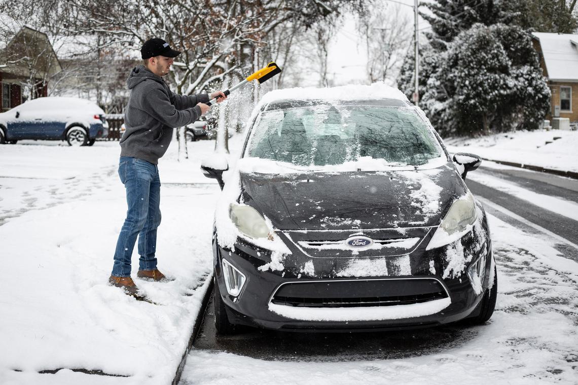 Jerad Eskridge scrapes snow and ice from his car Friday, Feb. 7, 202,0 in Lexington.