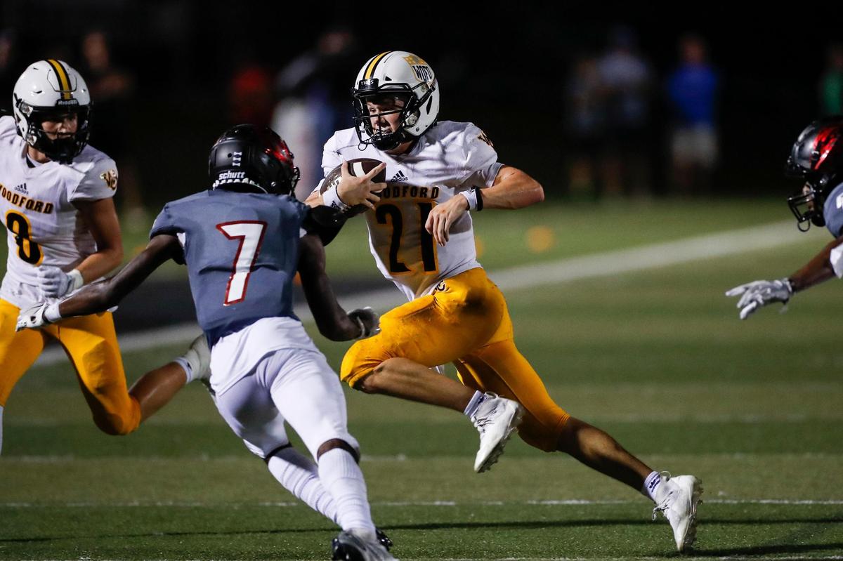 Woodford County Yellow Jackets Caleb Brown (1) rushes with the ball against Paul Laurence Dunbar Bulldogs Desmond Duncan (7) during the game at Paul Laurence Dunbar High School in Lexington, Ky., Friday, September 2, 2022.