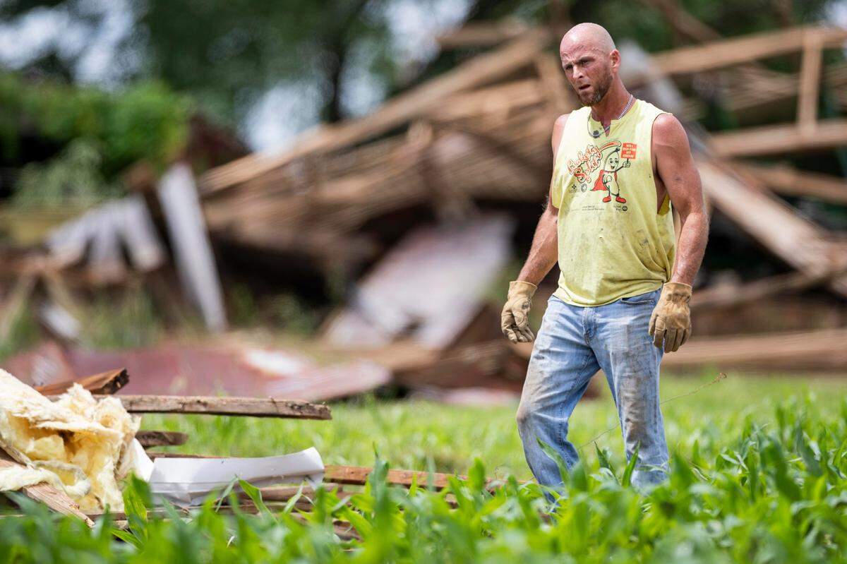 A farmer clears debris from the fields of his crops on Sunday, May 18, 2025, outside South Kentucky RECC in Somerset, Ky.