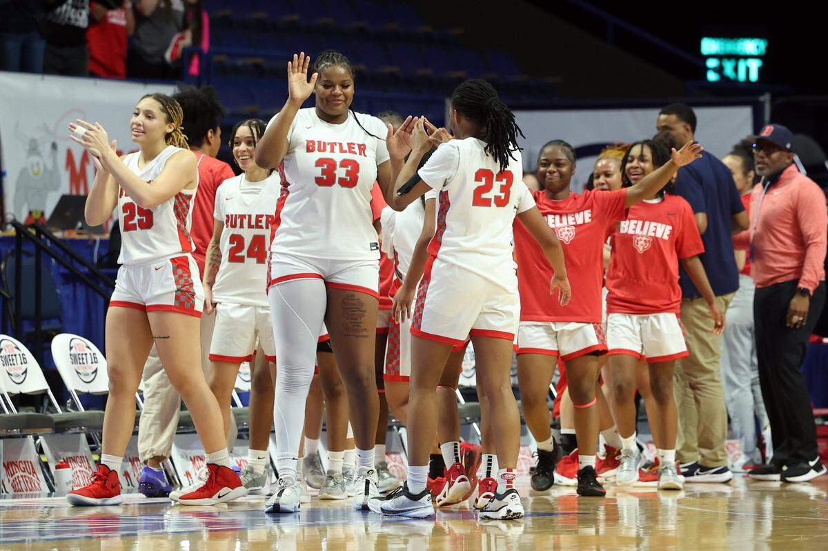 University of Kentucky signee Ramiya White (33), who led Butler with 16 points, celebrates with Imari Robinson (23) and other teammates during Wednesday night’s win in Rupp Arena.