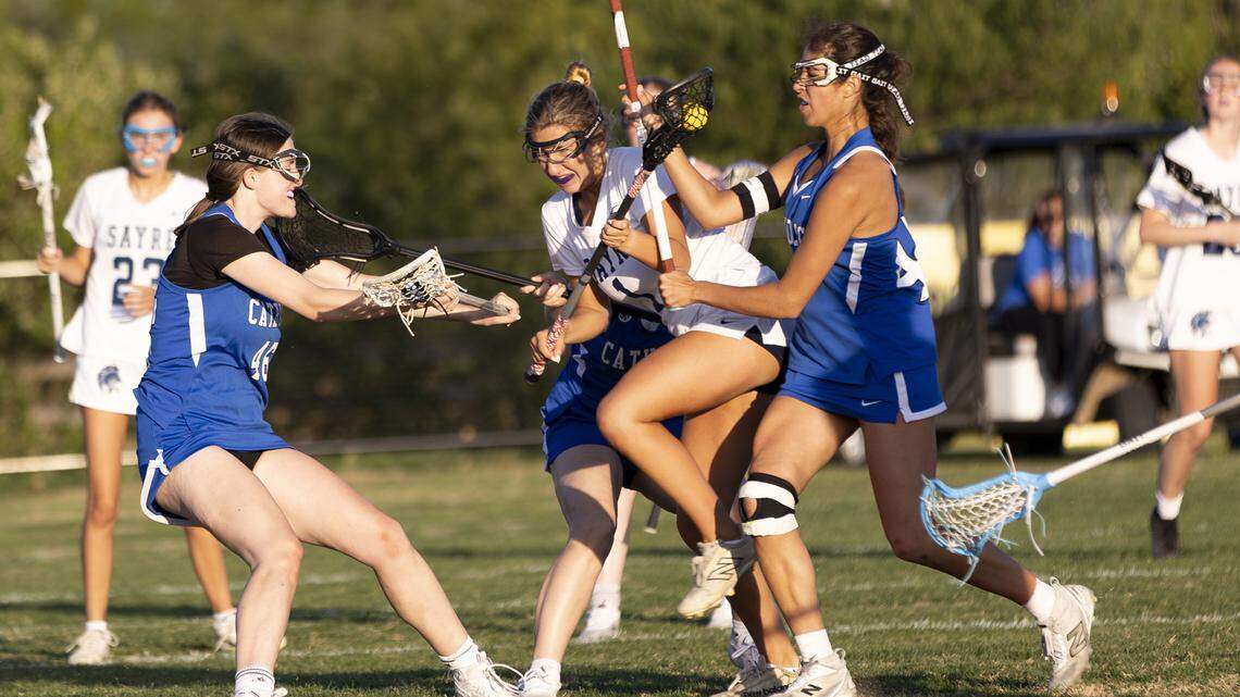 Sayre’s Madeline Mullikin (1) battles through three Lexington Catholic defenders, including Paige Langston, left, and Poppy Karthikeyan, right, during the Spartans’ 10-5 win over Lexington Catholic as the Sayre Athletic Complex on Thursday.